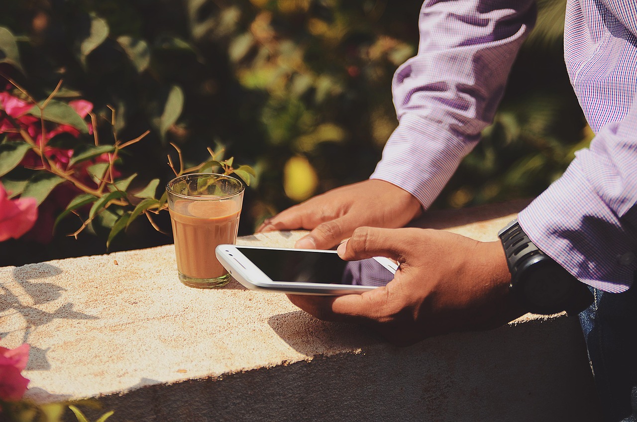 beverage, drink, hands, man, mobile phone, person, smartphone