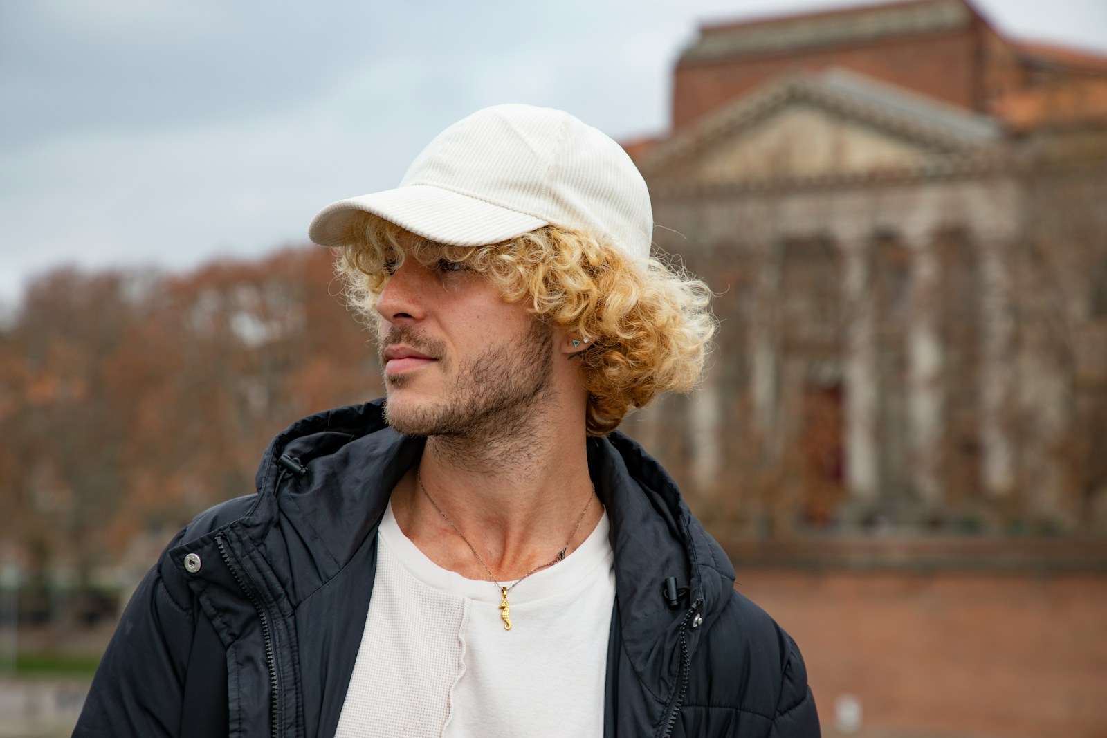 a man wearing a white hat standing in front of a building