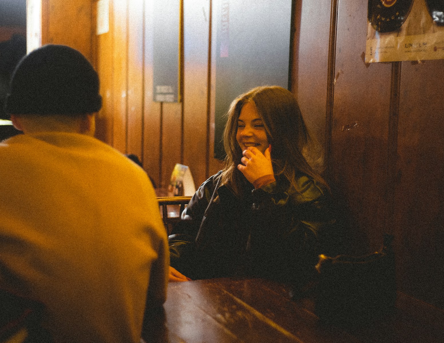a woman sitting at a table talking on a cell phone